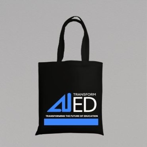 A black tote bag printed with the AI-TransformED logo