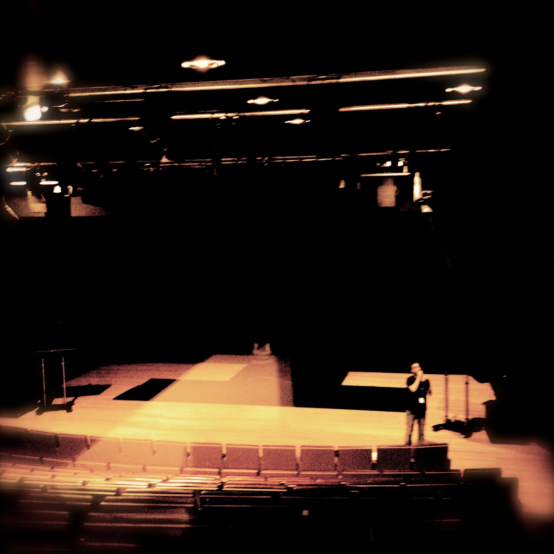 The Upper Stage of the Onassis Stegi, lit for EDIT, with the performer alone on the floor
