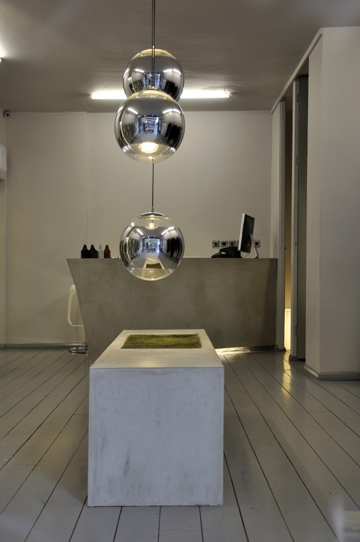 Three chrome spheres hanging above a concrete bench