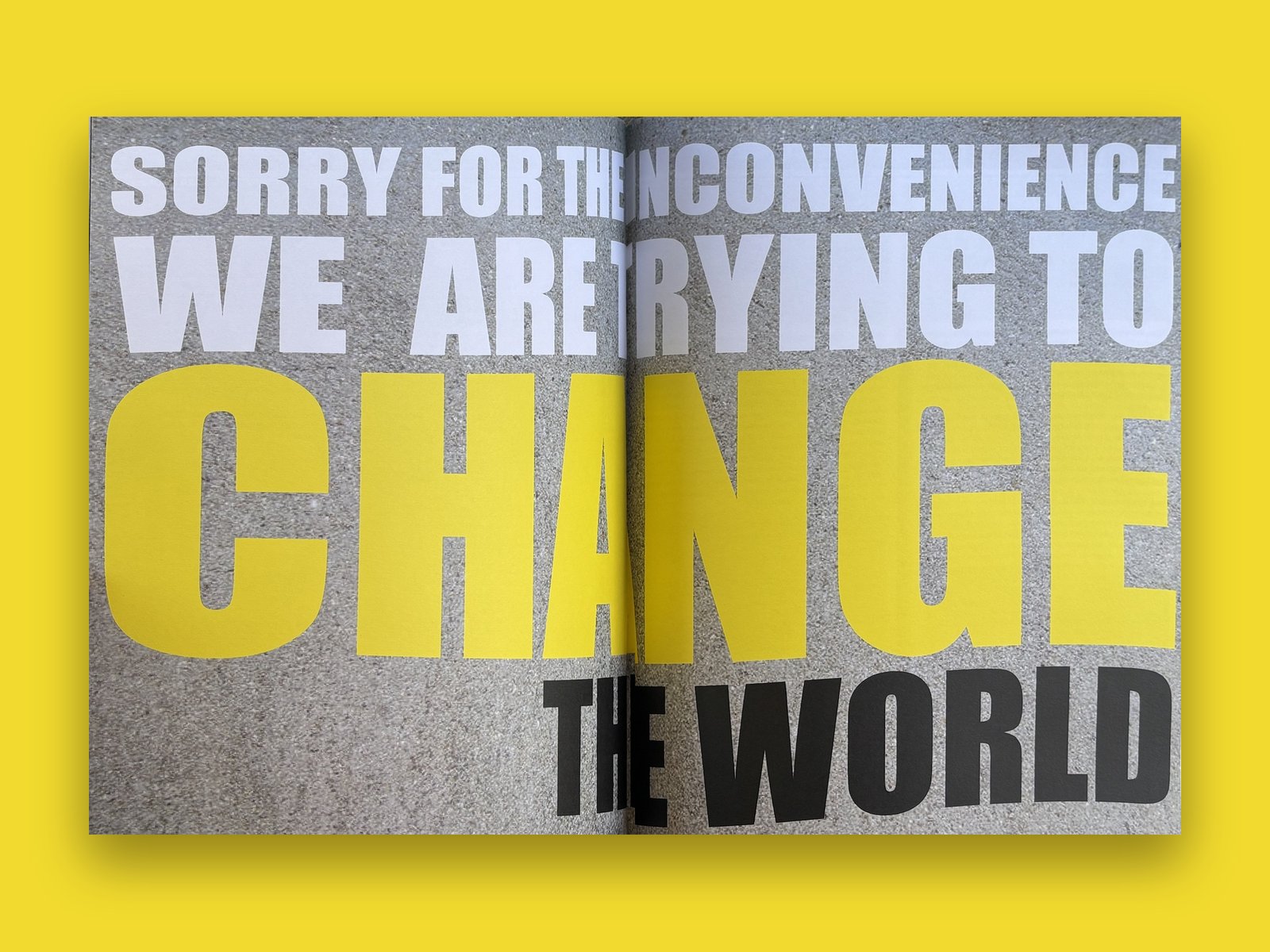 Spread in grey and yellow: 'Sorry for the inconvenience, we are trying to change the world'